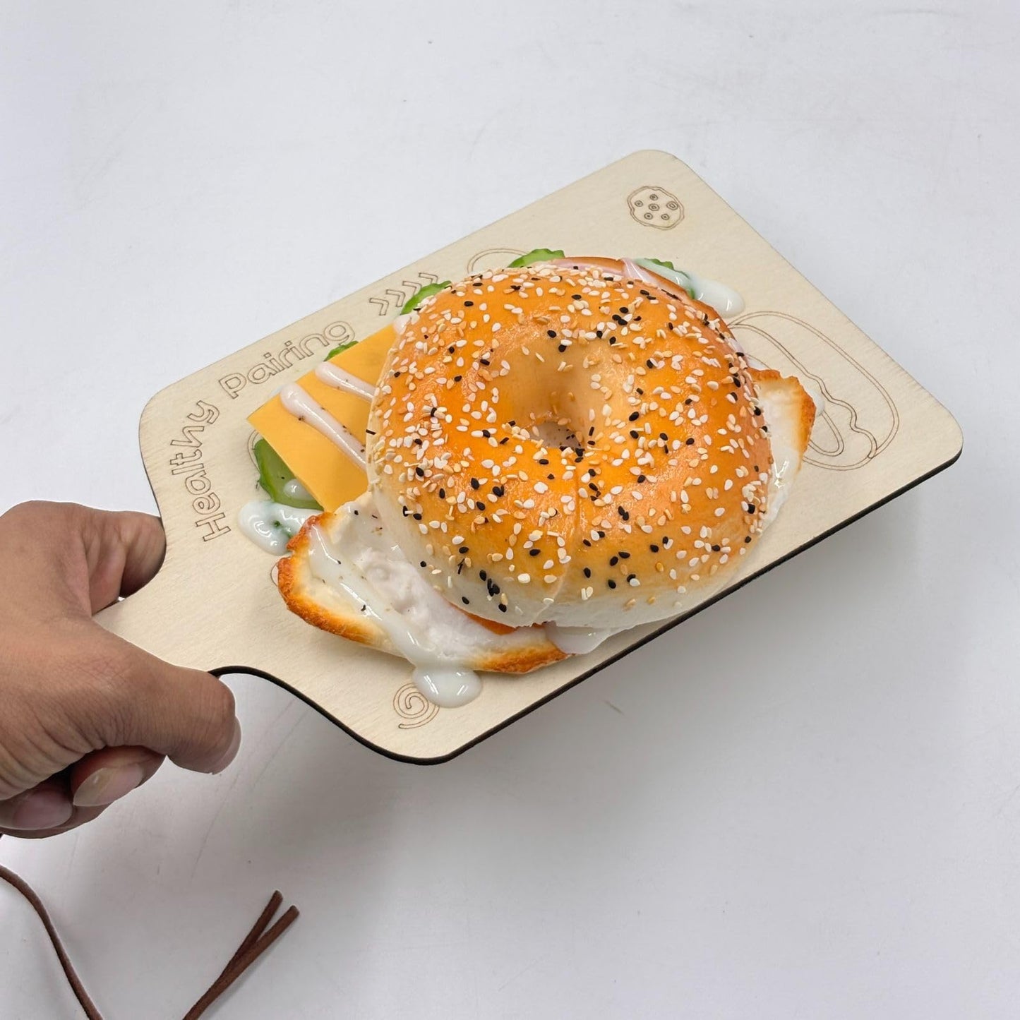 GURUBHAI EQUIPMENTS Artificial Bagel Sandwich with Cheese & Egg – Realistic Fake Food Prop with Wooden Board for Café Display, Bakery Showpiece, Photography & Restaurant Décor